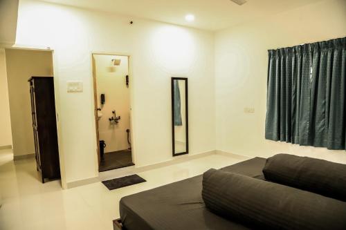 a living room with a couch and a mirror at G-2 Tulsi By The Peace in Chennai