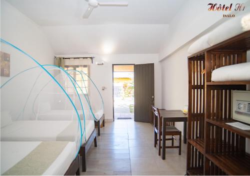 a room with two bunk beds and a desk and a table at HOTEL H1 ISALO in Ranohira