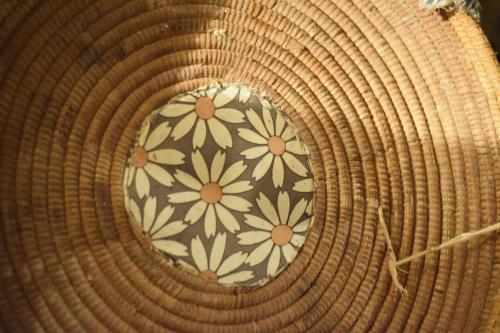 a brown basket with a flower pattern on it at Bissantica, heritage and charm in rural Sardinia in Lunamatrona