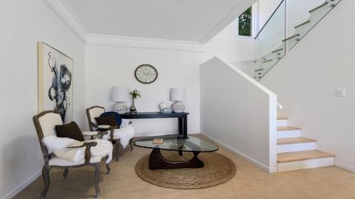 a living room with a glass table and chairs at Zephyr on Sapphire - Stunning private property on absolute beachfront in Sapphire Beach