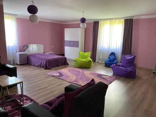 a room with two beds and a living room with purple at Hidden Paradise in Akhaltsikhe