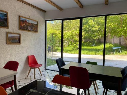 a room with a table and chairs and windows at Hidden Paradise in Akhaltsikhe