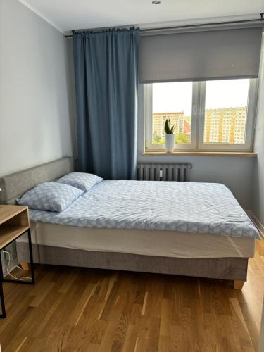 a bedroom with a bed and a window at Apartament Street Art ZASPA - wśród murali in Gdańsk