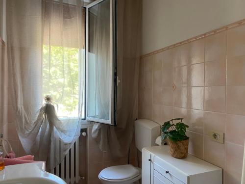 ein Badezimmer mit Toilette und Fenster in der Unterkunft Nebula Nook Luxury Apartment in Modena