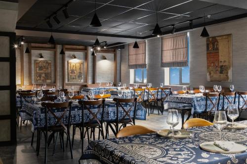 a dining room with tables and chairs with blue tablecloths at Akhaltsikhe Inn in Akhaltsikhe