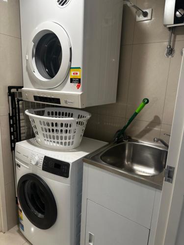 a small kitchen with a washing machine and a sink at Darwin City Retreat 2 bedrooms in Darwin