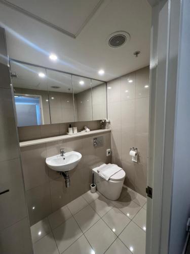 a bathroom with a sink and a toilet and a mirror at Darwin City Retreat 2 bedrooms in Darwin