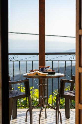 a table and two chairs on a balcony at Mirabilia Mountain Villa with a sea view in Áyios Vlásios