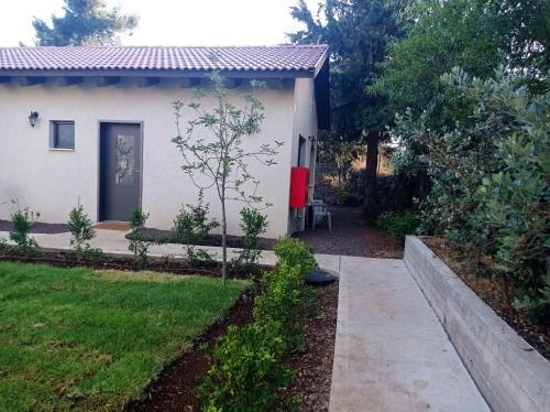a small white house with a pathway leading to it at דצ'א - Дача - Dacha in El-Rom