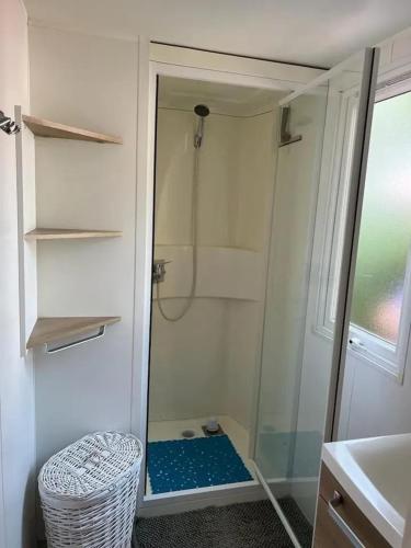 une douche avec une porte vitrée dans une salle de bain dans l'établissement Confortable bungalow proche de Vias avec piscine partagée, à Vias