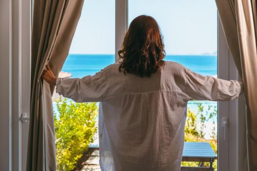 a woman looking out a window at the ocean at Mavilim Hotel in Kas