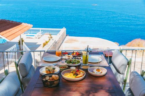 a table with plates of food on a balcony at Mavilim Hotel in Kas