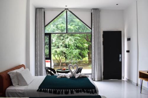 a bedroom with a bed and a large window at Vangvieng Lina hotel in Vang Vieng