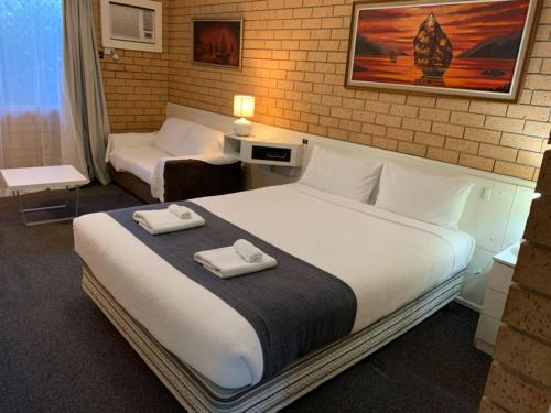 Ένα ή περισσότερα κρεβάτια σε δωμάτιο στο Aspley Pioneer Motel