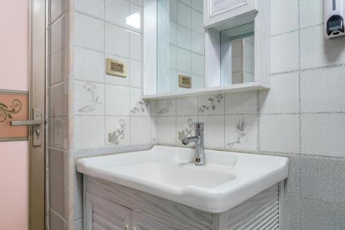 a bathroom with a white sink and a mirror at Fish House Youth Hostel in Guilin