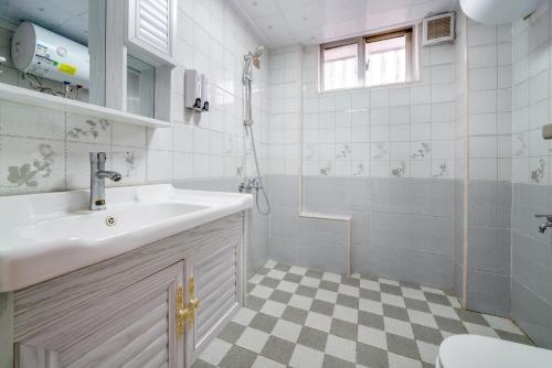 a bathroom with a sink and a shower at Fish House Youth Hostel in Guilin