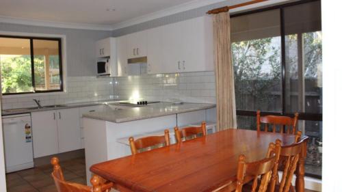 a kitchen with a wooden table and some chairs at Holiday With Your Pet! Wifi in Hawks Nest