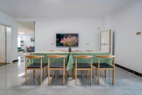 a dining room with a green table and chairs at Fish House Youth Hostel in Guilin
