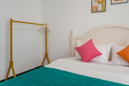 a bedroom with a bed with pink and orange pillows at Fish House Youth Hostel in Guilin