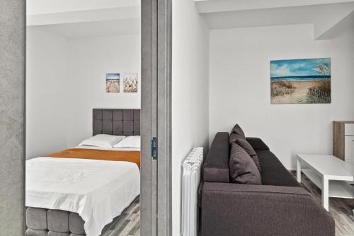 a bedroom with a bed and a couch at Azure Bliss Terrace Apartaments in Mamaia Nord