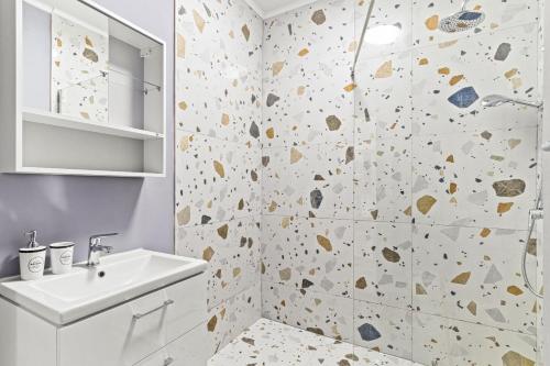 a bathroom with a white sink and a shower at Azure Bliss Terrace Apartaments in Mamaia Nord