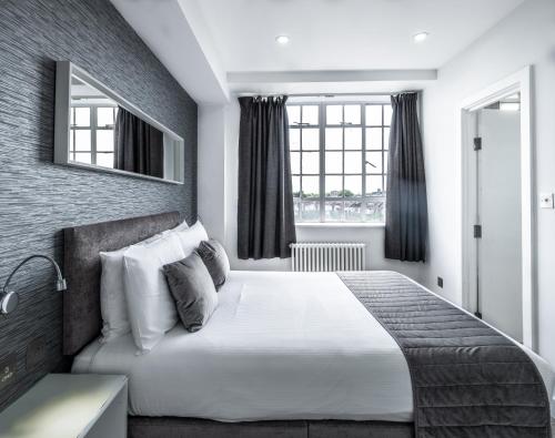 a bedroom with a large bed and a window at Chelsea Cloisters Serviced Apartments in London