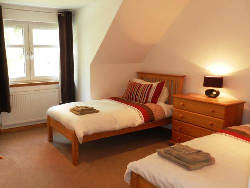 a bedroom with two twin beds and a window at Glen Rosa Lodge in Brodick