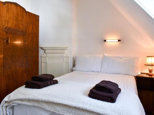 a bedroom with a bed with towels on it at Hamilton Terrace in Lamlash