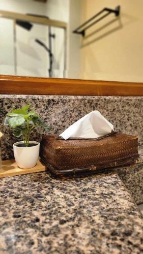 a brown purse sitting on a counter with a plant at Charming Garden View,Privately Owned Deluxe Room at The Manor by Mist and Pine in Baguio