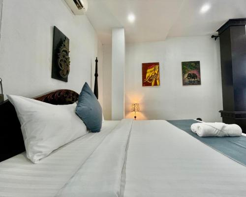 a bedroom with a large bed with white sheets and blue pillows at Villa Merry Lao Ban Aphay in Luang Prabang