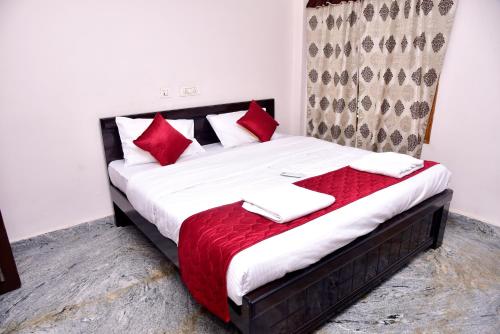蒂鲁帕蒂SHALOM RESIDENCE - 2BHK-AC Service Apartments, Premium amenities, Kitchen with Stovetop, WiFi的卧室里有一张带红色枕头的床