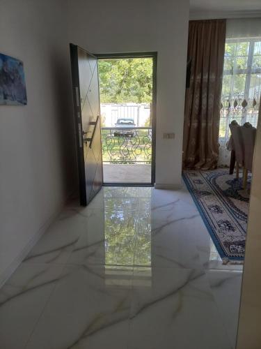 an empty room with a glass door with a view of a yard at Qəbələ Lux Home in Bum