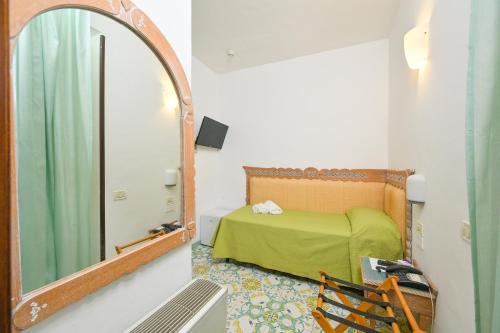 a bedroom with a green bed and a mirror at Av Isola Verde Hotel Thermal Spa in Ischia