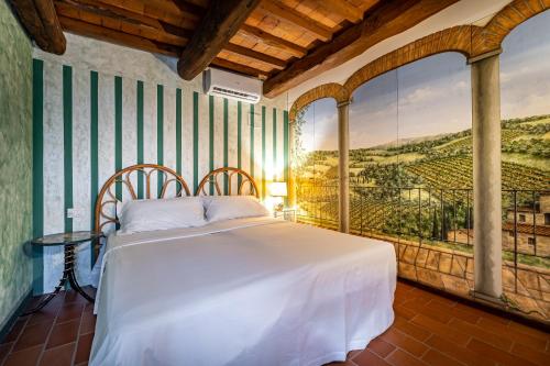 a bedroom with a bed with a painting on the wall at Villa dei Pavoni - Holiday Villa in Montauto