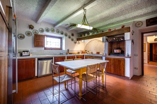 a kitchen with a table and chairs in it at Villa dei Pavoni - Holiday Villa in Montauto