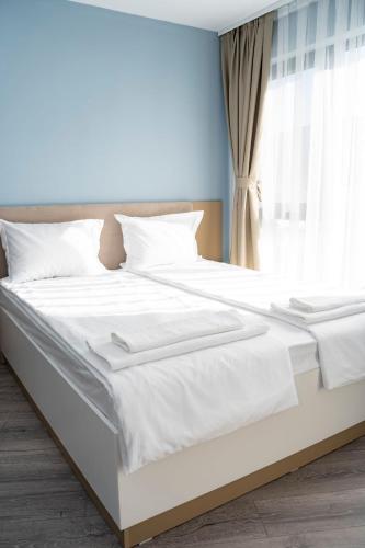 a white bed in a bedroom with a window at Ivalena APART in Kranevo