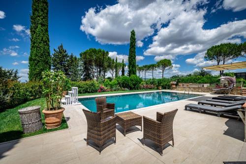 a swimming pool with wicker chairs and a patioitures at Villa dei Pavoni - Holiday Villa in Montauto