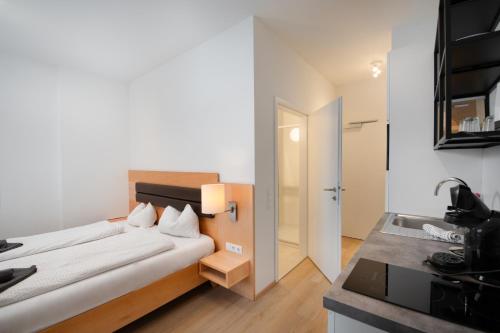 a bedroom with a bed and a sink in a room at Flataid Apartments Marienbrau Graz Waltendorf in Hart bei Graz
