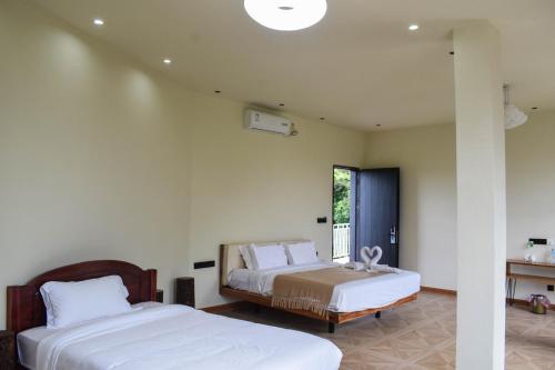 a bedroom with two beds and a window at Vangvieng Lina hotel in Vang Vieng