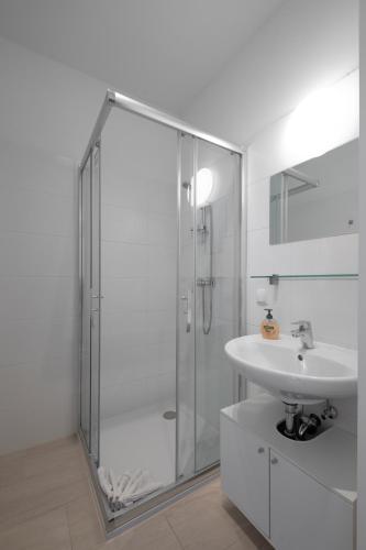 a white bathroom with a shower and a sink at Flataid Apartments Marienbrau Graz Waltendorf in Hart bei Graz