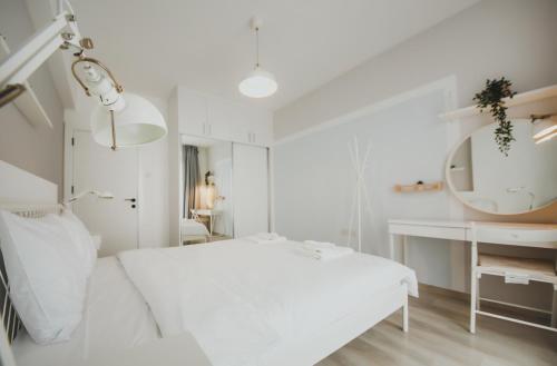 a white bedroom with a bed and a mirror at Caesar Blue Seaside Luxury Apartments in Kalecik