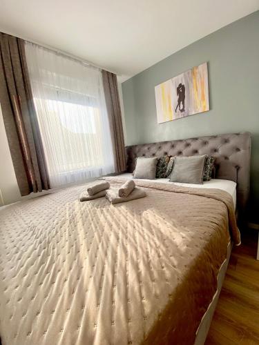 a bedroom with a large bed with two towels on it at Black & White Hideaway with garage in Ljubljana