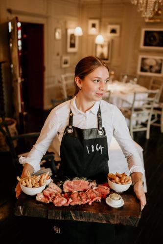 a woman in an apron standing behind a table with food at HIGHFIELD in Great Driffield