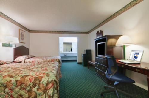 a hotel room with a bed and a desk with a computer at Five Star Inn Burleson in Burleson