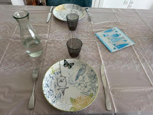 a table with plates and utensils on a table at Studio rénové à neuf in La Tranche-sur-Mer