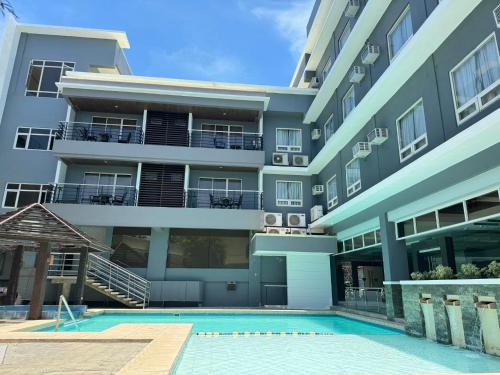 an apartment building with a swimming pool in front of it at Circle Inn - Iloilo City Center in Iloilo City
