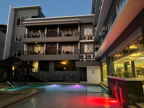 a building with a swimming pool in front of a building at Circle Inn - Iloilo City Center in Iloilo City