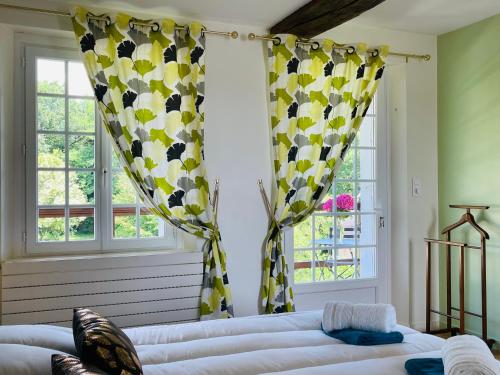 a living room with yellow and white curtains and a couch at Domaine Jeanne de Laval in La Bohalle