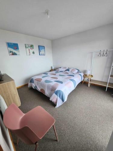 une chambre avec un lit et une chaise rose dans l'établissement Appartement tout confort, à Thollon-les-Mémises