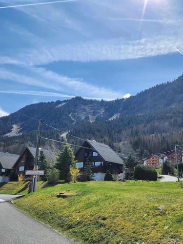 une maison sur le côté d'une route avec une montagne dans l'établissement Appartement tout confort, à Thollon-les-Mémises